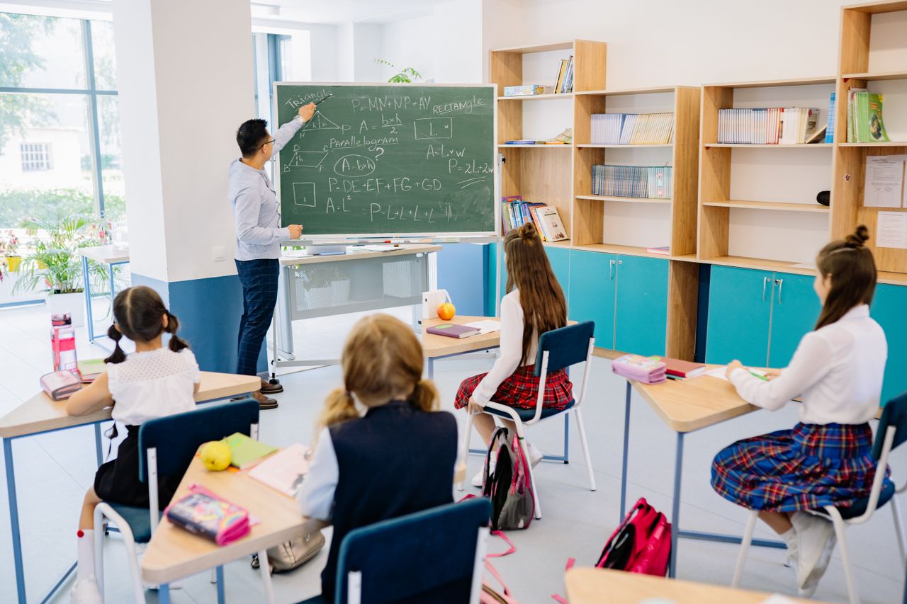 5 things that startup needs to do to succeed Children in a classroom focused on a math lesson with a teacher. Bright and educational atmosphere.