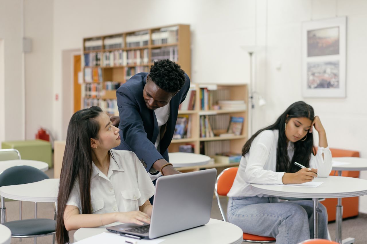 Crafting Captivating Headlines: Your awesome post title goes here Students receiving guidance from a teacher in a well-equipped classroom.